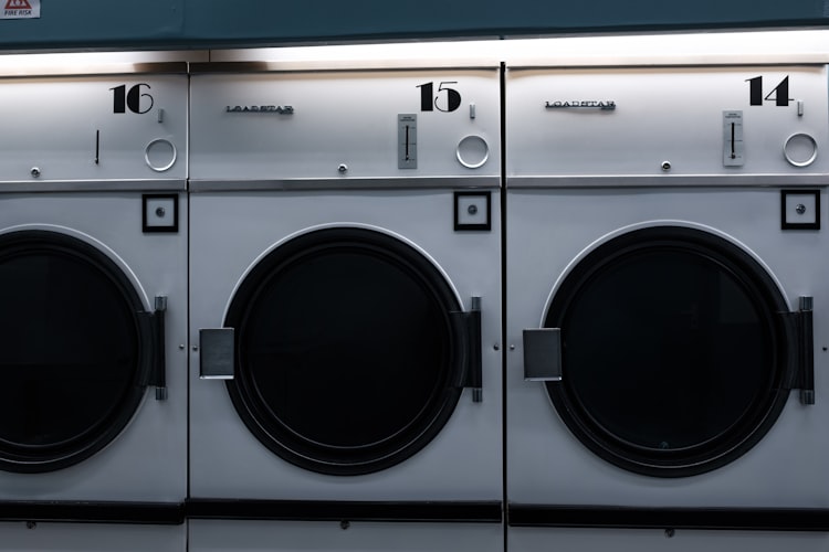 Deretan mesin cuci industri bernomor 14, 15, dan 16 di sebuah laundry